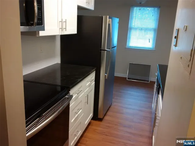 a kitchen with stainless steel appliances granite countertop a refrigerator and a stove