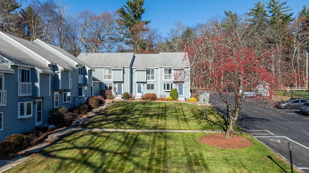 1 Acadia Kimball Road, Unit 1 Amesbury, MA 01913 - Photo 2 of 21 a view of a white house with a yard patio and fire pit
