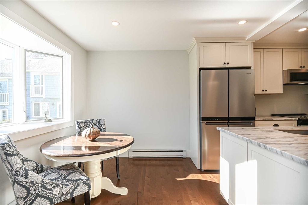 1 Acadia Kimball Road, Unit 1 Amesbury, MA 01913 - Photo 5 of 21 a kitchen with stainless steel appliances a sink a table and chairs