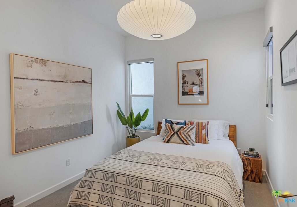 504 Paragon Loop Palm Springs, CA 92262 - Photo 16 of 45 a bedroom with a large bed and a potted plant