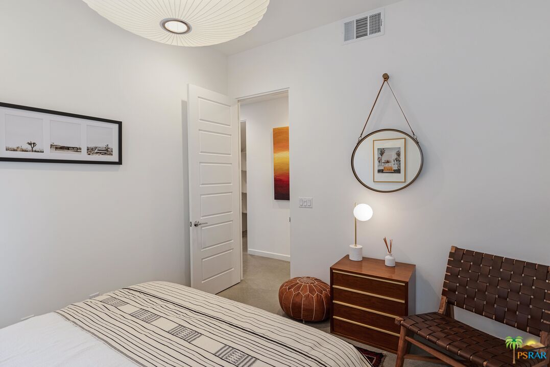 504 Paragon Loop Palm Springs, CA 92262 - Photo 17 of 45 a bedroom with a bed and a chandelier