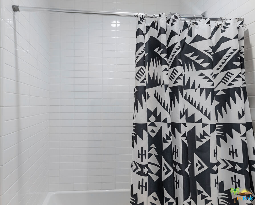 504 Paragon Loop Palm Springs, CA 92262 - Photo 19 of 45 a bathroom with a bathtub and shower curtain