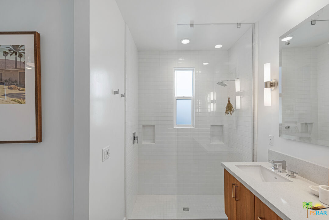 504 Paragon Loop Palm Springs, CA 92262 - Photo 35 of 45 a bathroom with a shower sink vanity and mirror