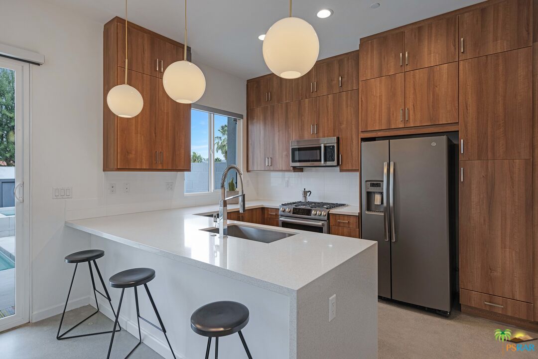 504 Paragon Loop Palm Springs, CA 92262 - Photo 10 of 45 a kitchen with stainless steel appliances a refrigerator a sink cabinets and a counter top space