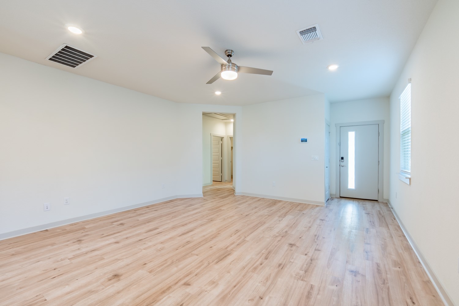 10801 Meris Lane Austin, TX 78754 - Photo 5 of 18 An inviting entry opens to a spacious, bright living area featuring modern wood flooring and a contemporary ceiling fan.