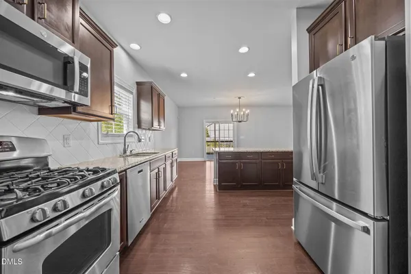 a kitchen with stainless steel appliances granite countertop a refrigerator stove and sink