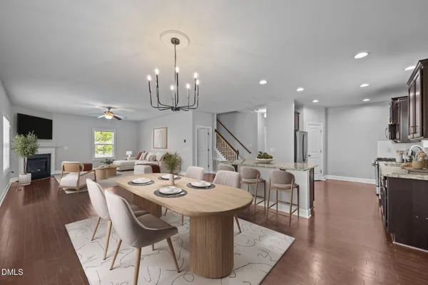 an empty room with wooden floor chandelier and windows