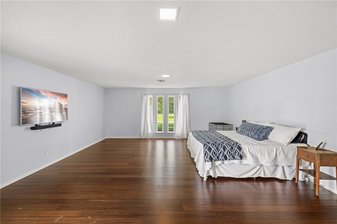 871 Cazey Loop Franklin, TX 77856 - Photo 20 of 42 a view of a bedroom with wooden floor and a window