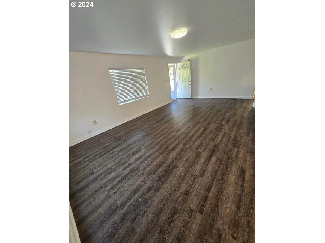 12450 Southwest Fischer Road, Unit 143 Portland, OR 97224 - Photo 11 of 11 a view of an empty room with wooden floor