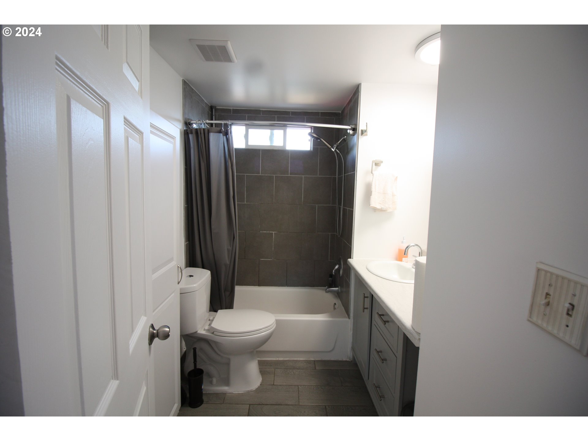 12450 Southwest Fischer Road, Unit 143 Portland, OR 97224 - Photo 5 of 11 a bathroom with a toilet a sink and shower