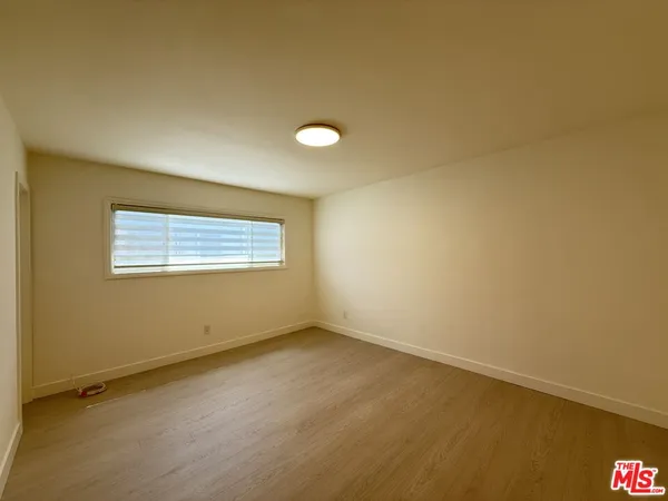 a view of room with window and wooden floor
