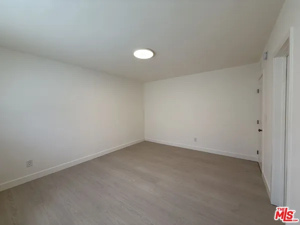 a view of a room with wooden floor and fan