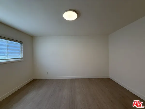 a view of a room with wooden floor and white walls