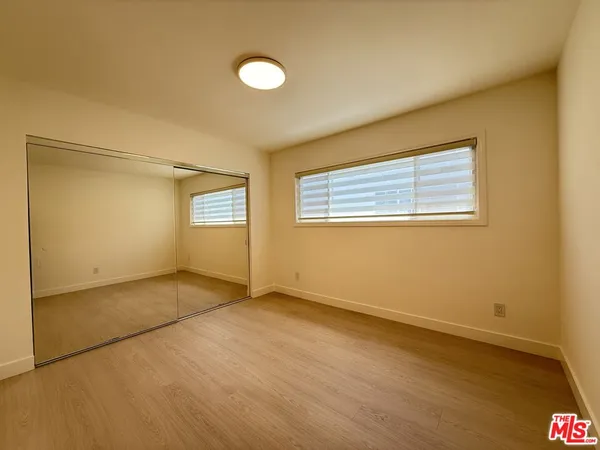 an empty room with windows and closet