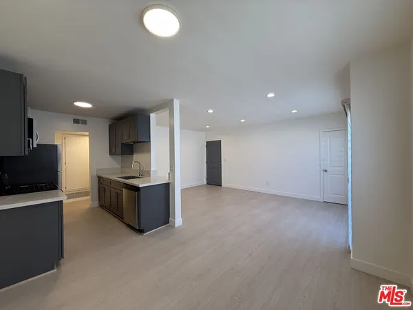 a kitchen with stainless steel appliances granite countertop a refrigerator and a stove top oven