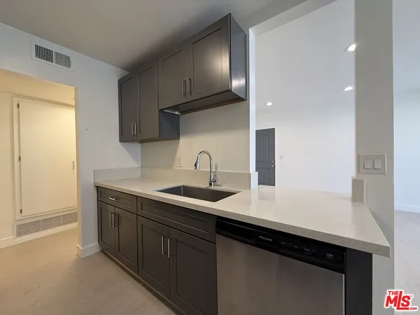 a kitchen with stainless steel appliances granite countertop a sink a stove and a microwave
