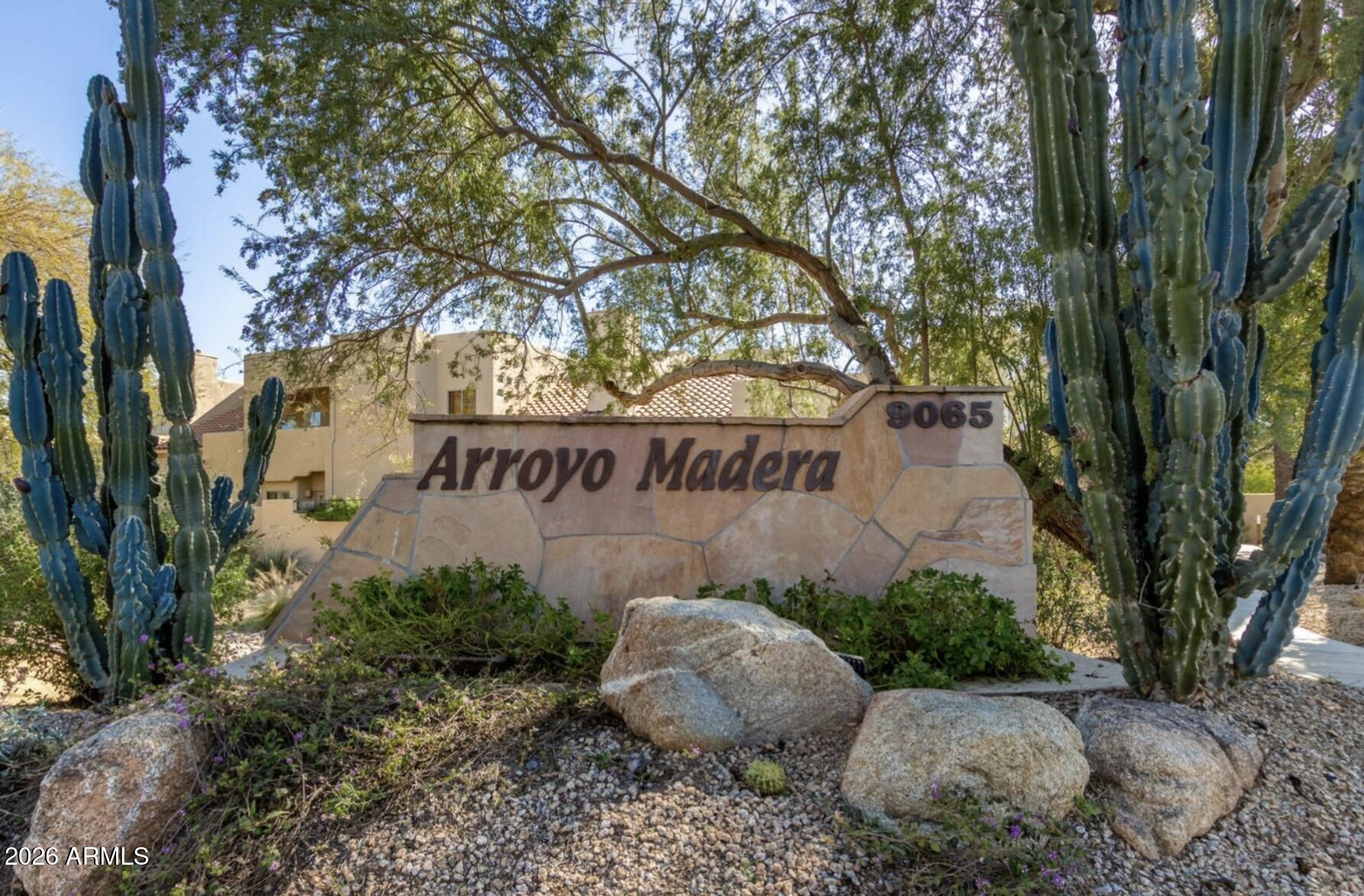 a view of a sign board with large trees