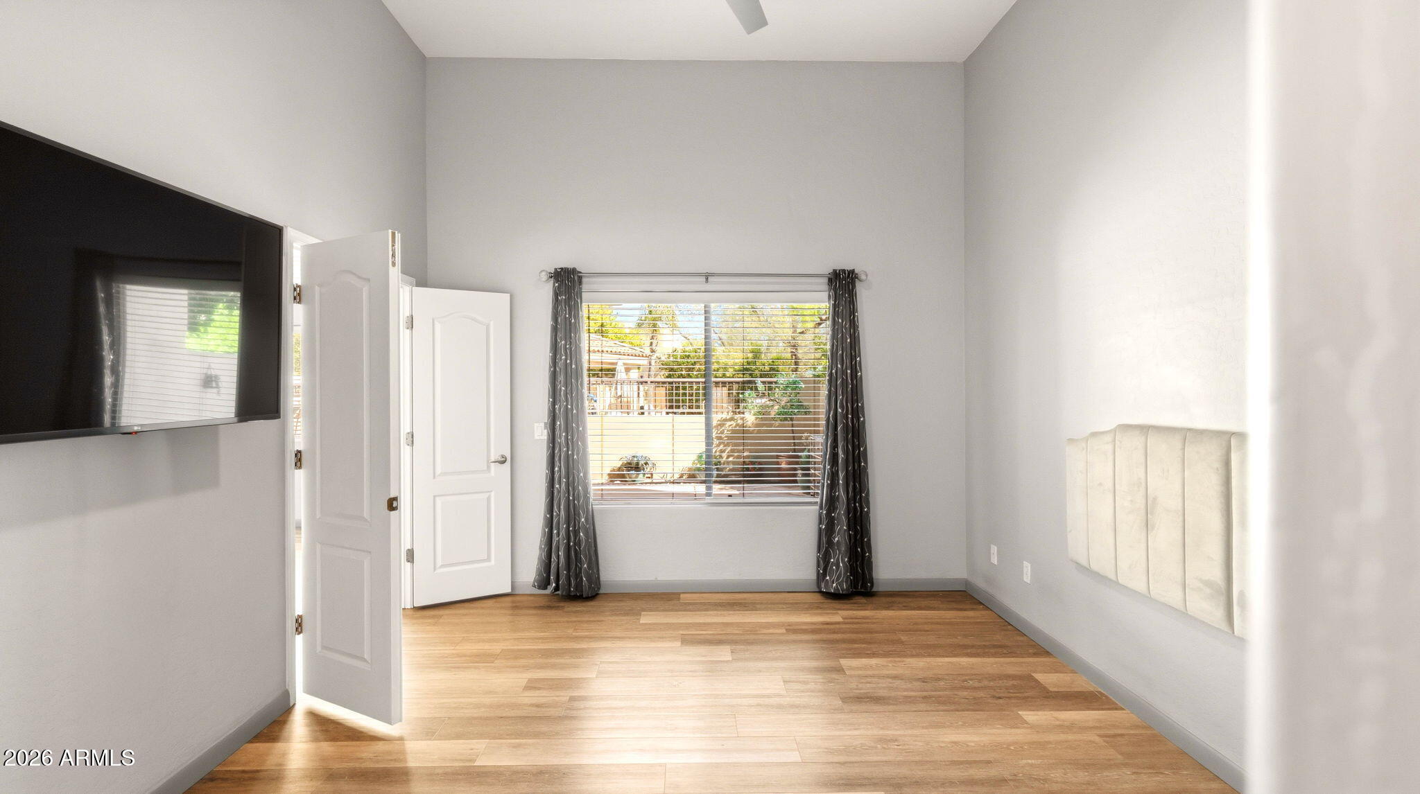 9065 East Gary Road, Unit 126 Scottsdale, AZ 85260 - Photo 20 of 37 a view of an empty room with wooden floor and a window