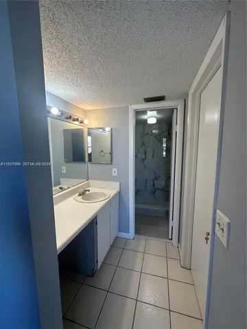 a bathroom with a sink a mirror and a shower