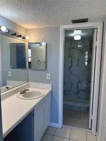 a bathroom with a sink a shower and a mirror