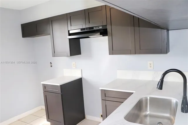 a kitchen with a sink and a stove top oven