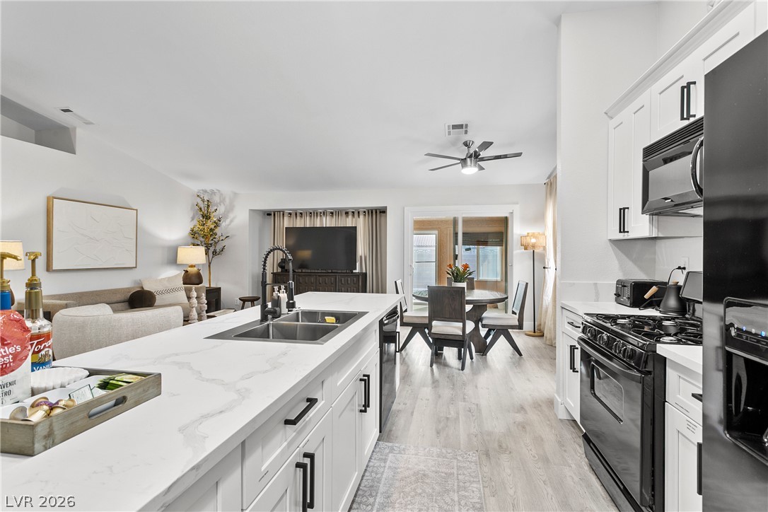 101 Beaver Ridge Avenue North Las Vegas, NV 89031 - Photo 8 of 42 A luminous open-concept layout unites the kitchen, dining, and living areas with cohesive design.