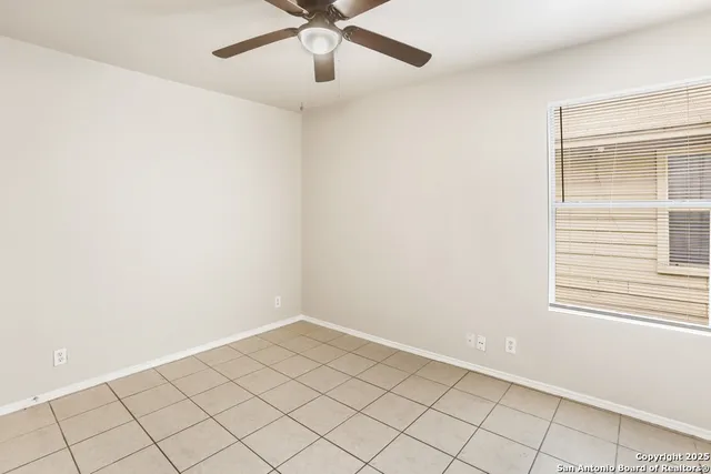 an empty room with a ceiling fan and window