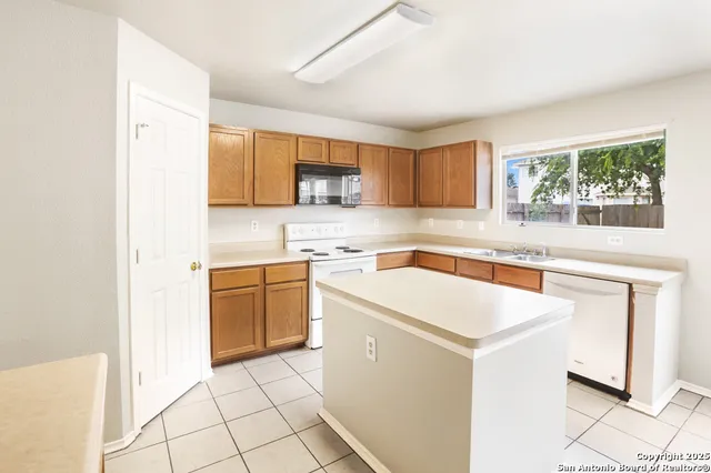 a kitchen with a sink a stove a microwave and a refrigerator