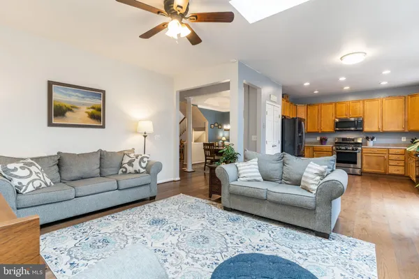 a living room with furniture kitchen view and a large window