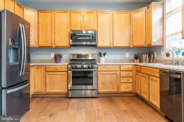 a kitchen with stainless steel appliances a stove sink and cabinets
