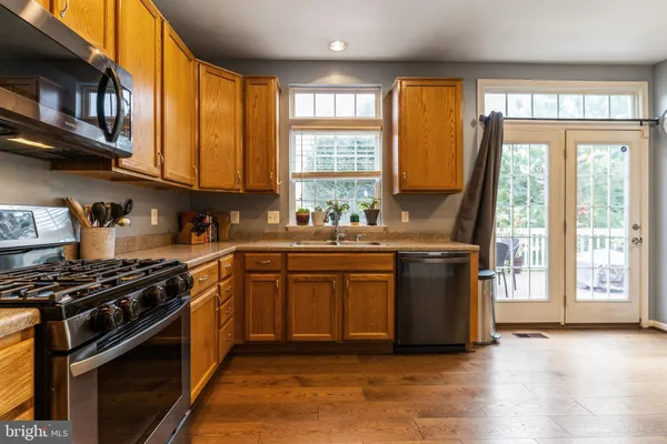 a kitchen with stainless steel appliances granite countertop a stove a sink and a microwave