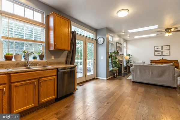 a large kitchen with stainless steel appliances a large window a sink and a counter top space