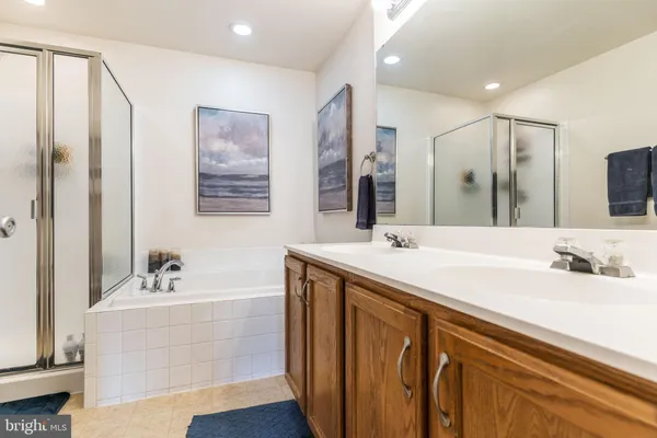 a bathroom with a double vanity sink a mirror and a bathtub