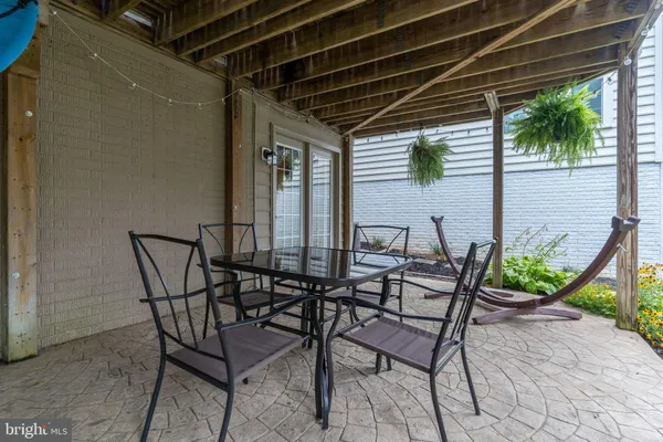 a view of two chairs and table in the patio