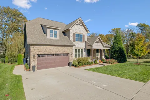 a front view of a house with a garden and yard