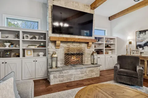 a living room with furniture kitchen view and a chandelier