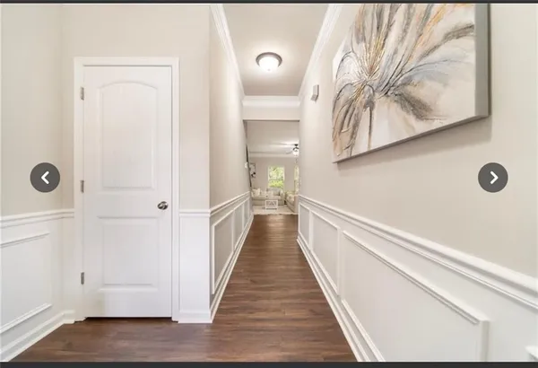 a view of a hallway with wooden floor and closet