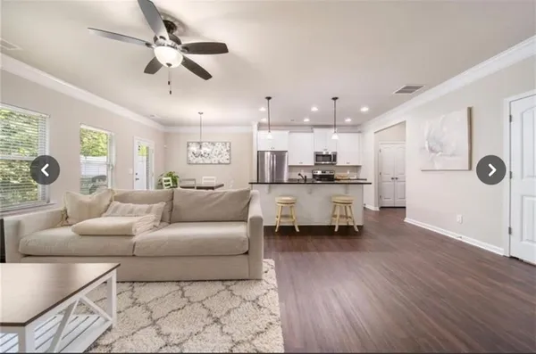 a living room with furniture and kitchen view