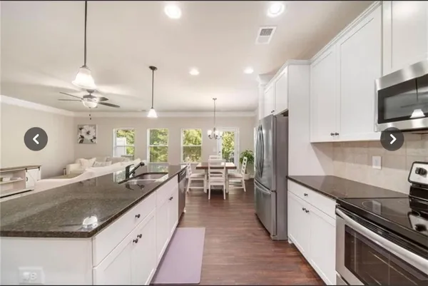 a kitchen with counter top space a sink appliances and cabinets