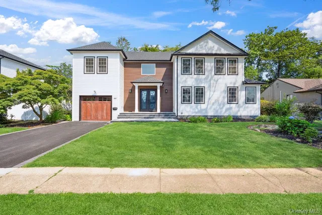 a front view of a house with a yard and trees