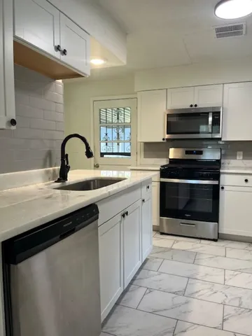 a kitchen with a sink and a stove top oven