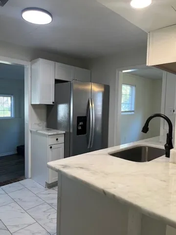 a kitchen with stainless steel appliances kitchen island a refrigerator sink and cabinets