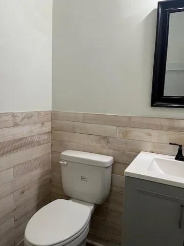 a bathroom with a toilet a sink and a mirror