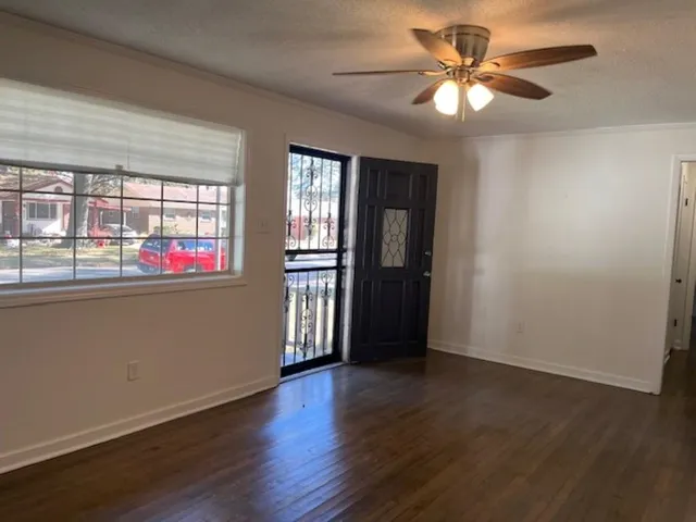 an empty room with wooden floor and windows