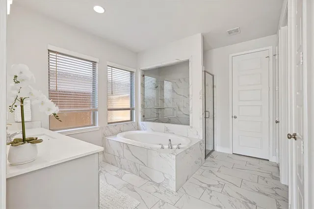 a bathroom with a tub sink and mirror