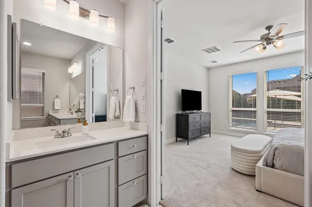 a spacious bathroom with a double vanity sink a large mirror and a bathtub