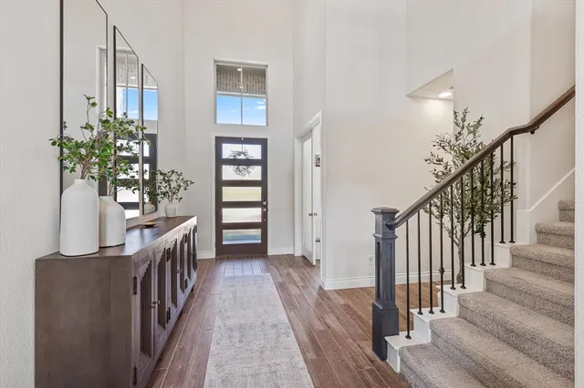 a view of a hallway with wooden floor and staircase