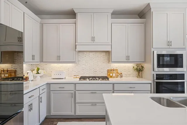 a kitchen with granite countertop a sink a stove and cabinets