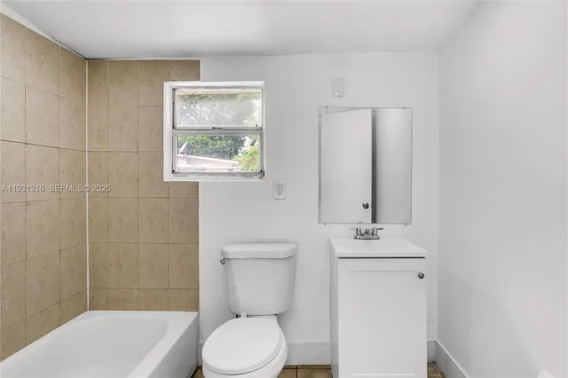 a bathroom with a toilet a sink and mirror