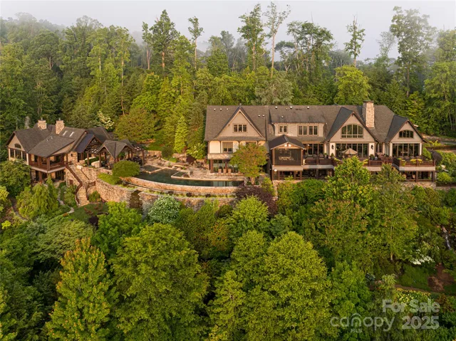 a view of a house with a big yard and large trees